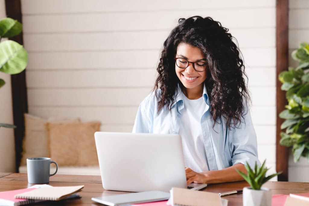 Happy successful young african-american businesswoman working on a laptop