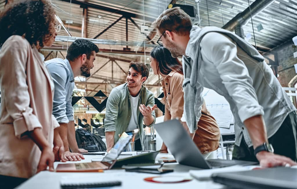 A team leaning over a table collaborating