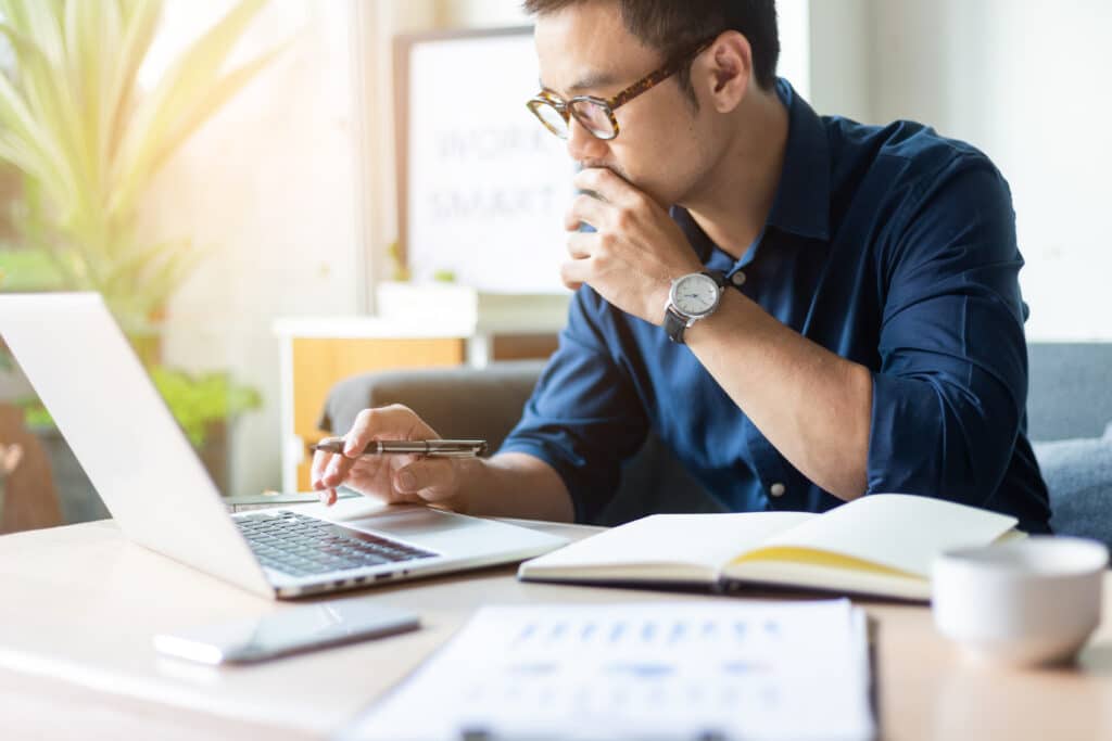 man sitting at a desk in front of his laptop