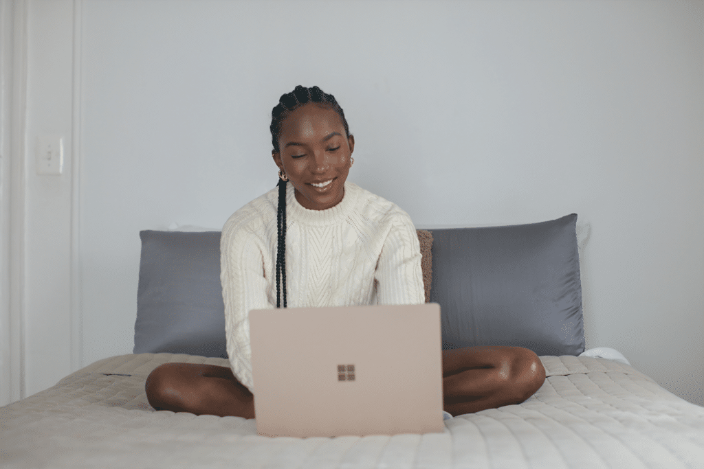 young black woman smiling at laptop